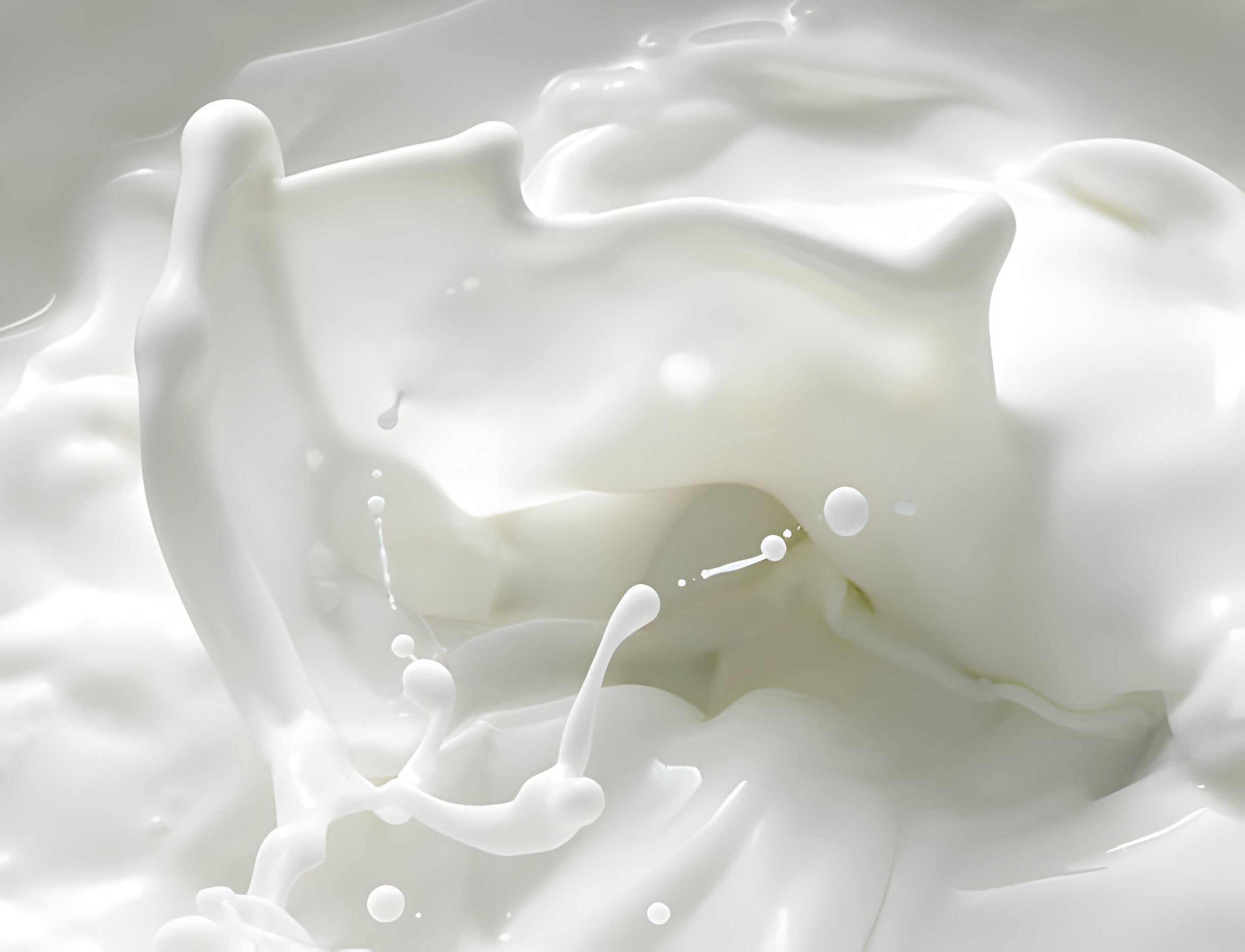 Nahaufnahme von spritzender Milch, zeigt dynamische Bewegung und fließende Flüssigkeitsformen in verschiedenen Höhen.